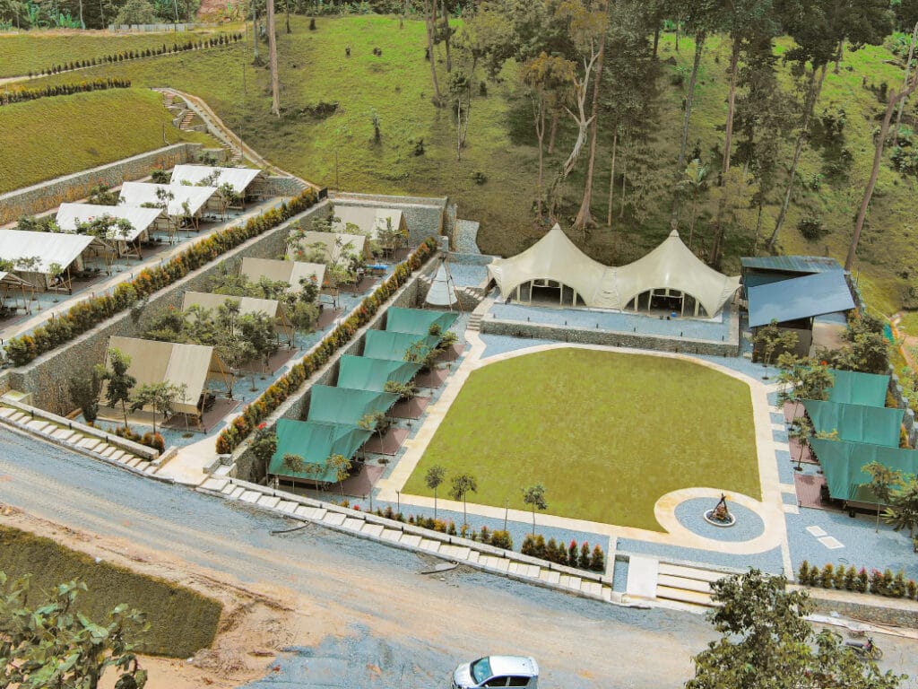 Side-by-side glamping tents and tipi at IKAN Glampsite, Janda Baik, set against green hills, depicting the modern facilities and unique structures that distinguish glamping from conventional camping in Malaysia.
