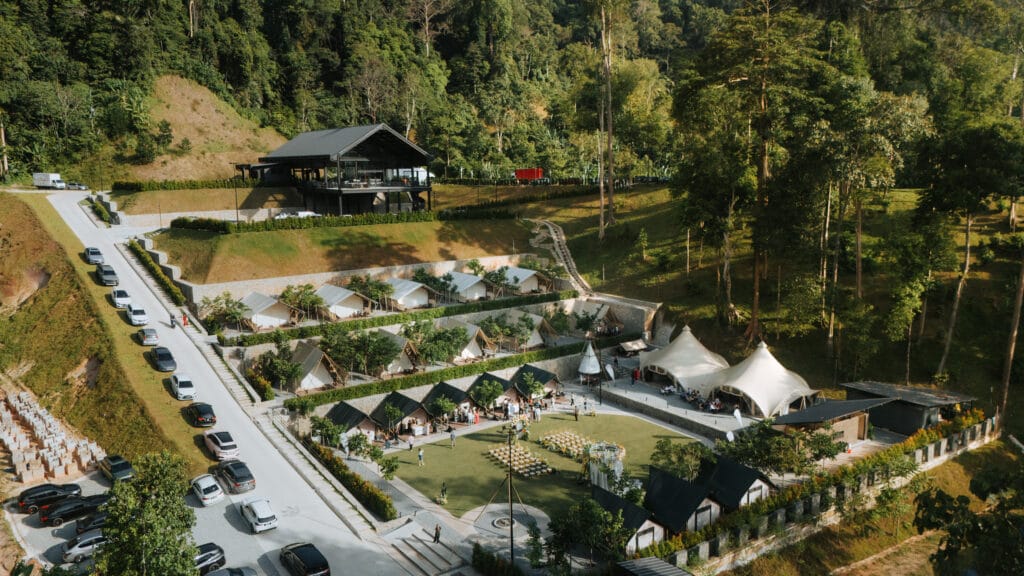 Aerial view of IKAN Glampsite’s wedding and ROM glamping venue in Janda Baik, Bentong, showcasing tented event spaces, landscaped pathways, and surrounding forest scenery.