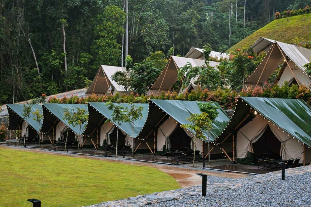 Spacious glamping tent setup at IKAN Glampsite with outdoor deck, seating area, and cosy interior