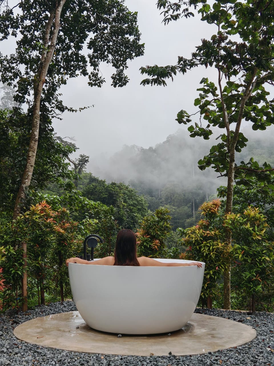 Outdoor bathtub in lush greenery at a glamping site in Bentong, offering a relaxing nature escape experience