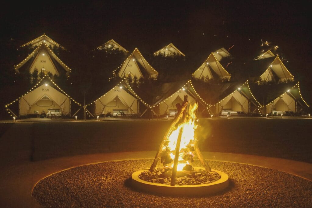 Nighttime glamping tents with campfire at IKAN Glampsite, surrounded by nature in Janda Baik